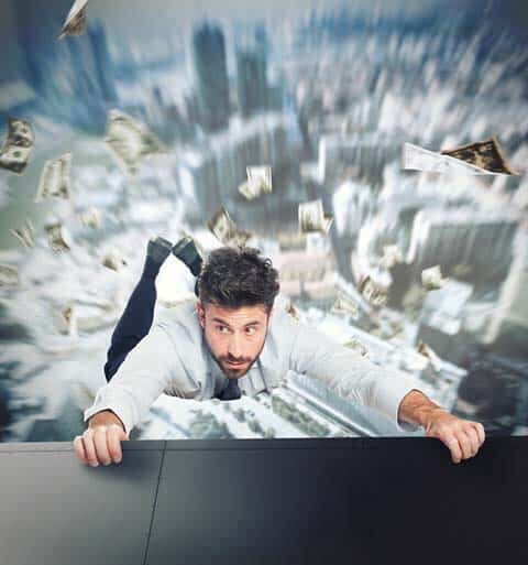 Crisis communications can prevent business disasters. Businessman hanging on a ledge.