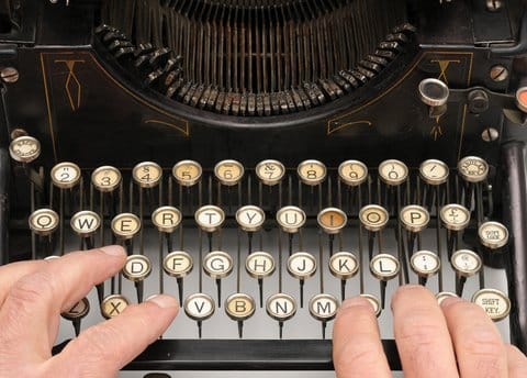 Writing a book with a ghostwriter will involve putting hands on a keyboard, although not actually a typewriter, as in this photo.